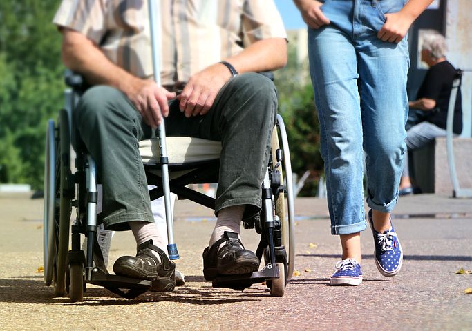 disabled man being assisted by a support assistant